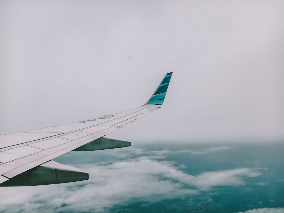 cheap airfare for travel nurses with a calendar, boarding pass, and suitcase on a clean editorial cover