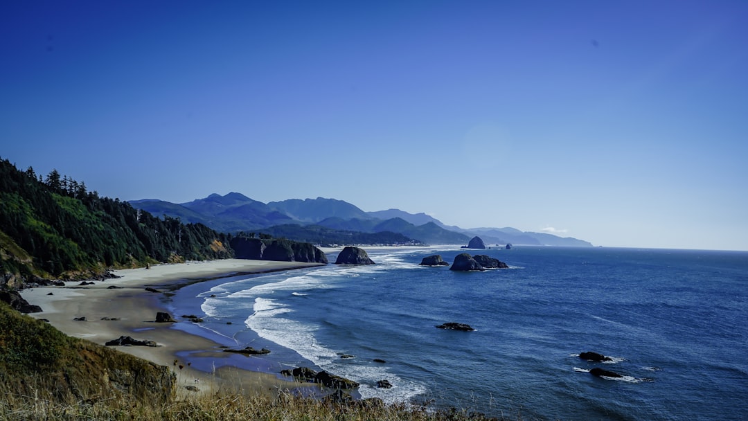 Pacific Northwest road trip itinerary cover – coastal highway, rainforest, and mountain peaks at sunrise